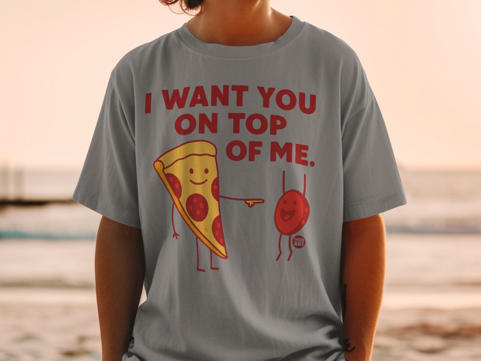T-shirt with red text "I WANT YOU ON TOP OF ME" and cartoon pizza slice and tomato.