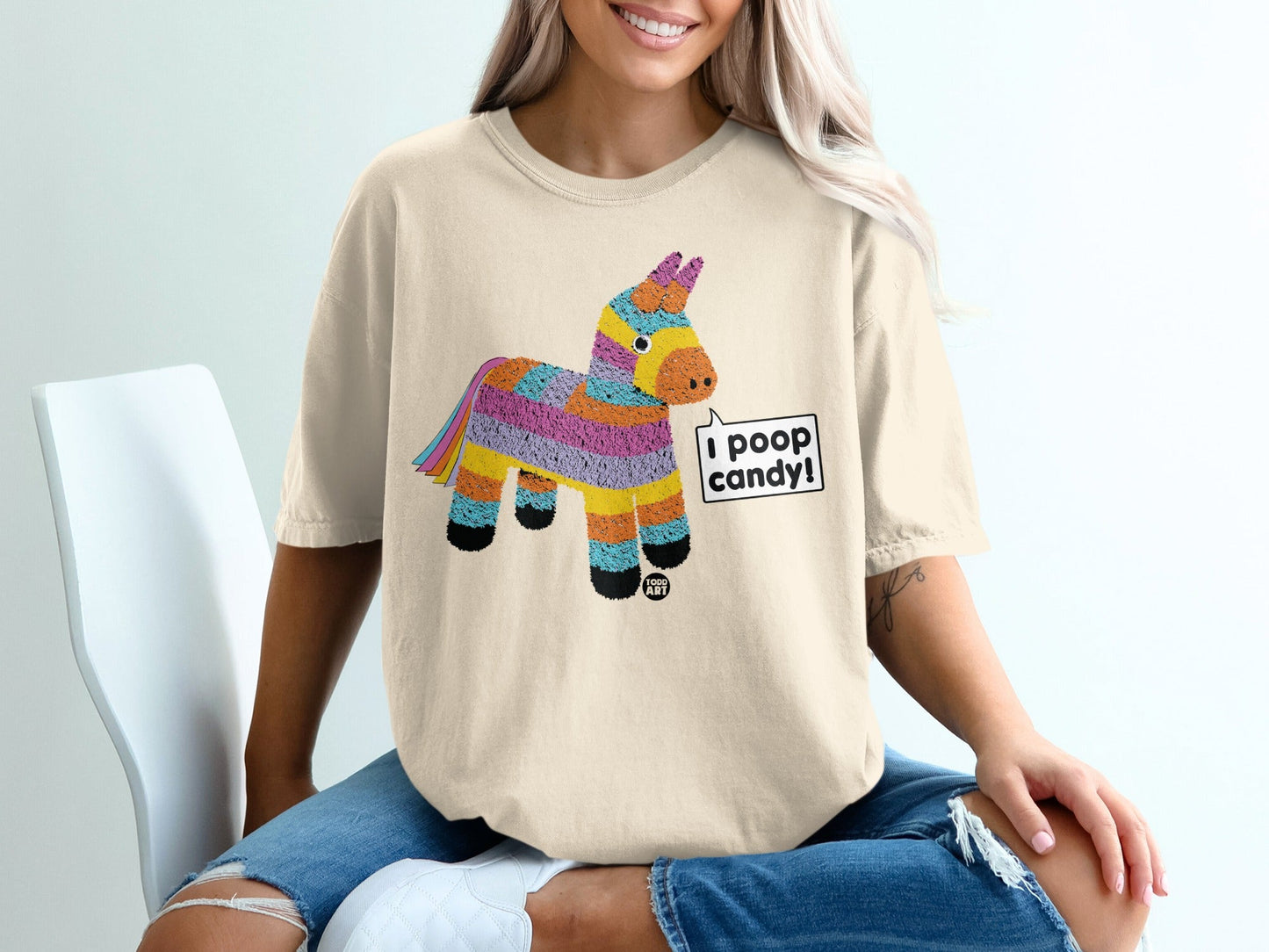 Beige t-shirt with a colorful pi√±ata graphic and "I poop candy!" speech bubble.