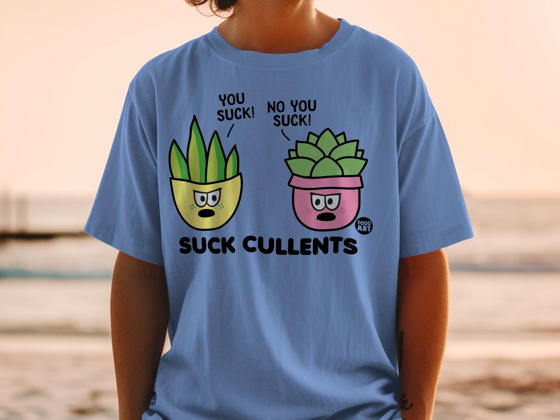 Blue t-shirt with cartoon succulents saying "YOU SUCK!" and "NO YOU SUCK!".