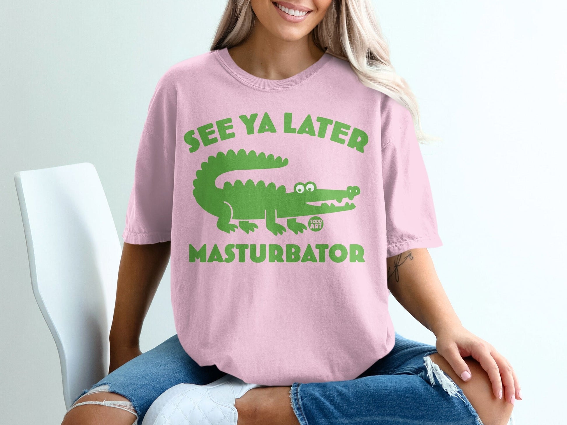 Pink t-shirt with green alligator graphic and "SEE YA LATER MASTURBATOR" text.