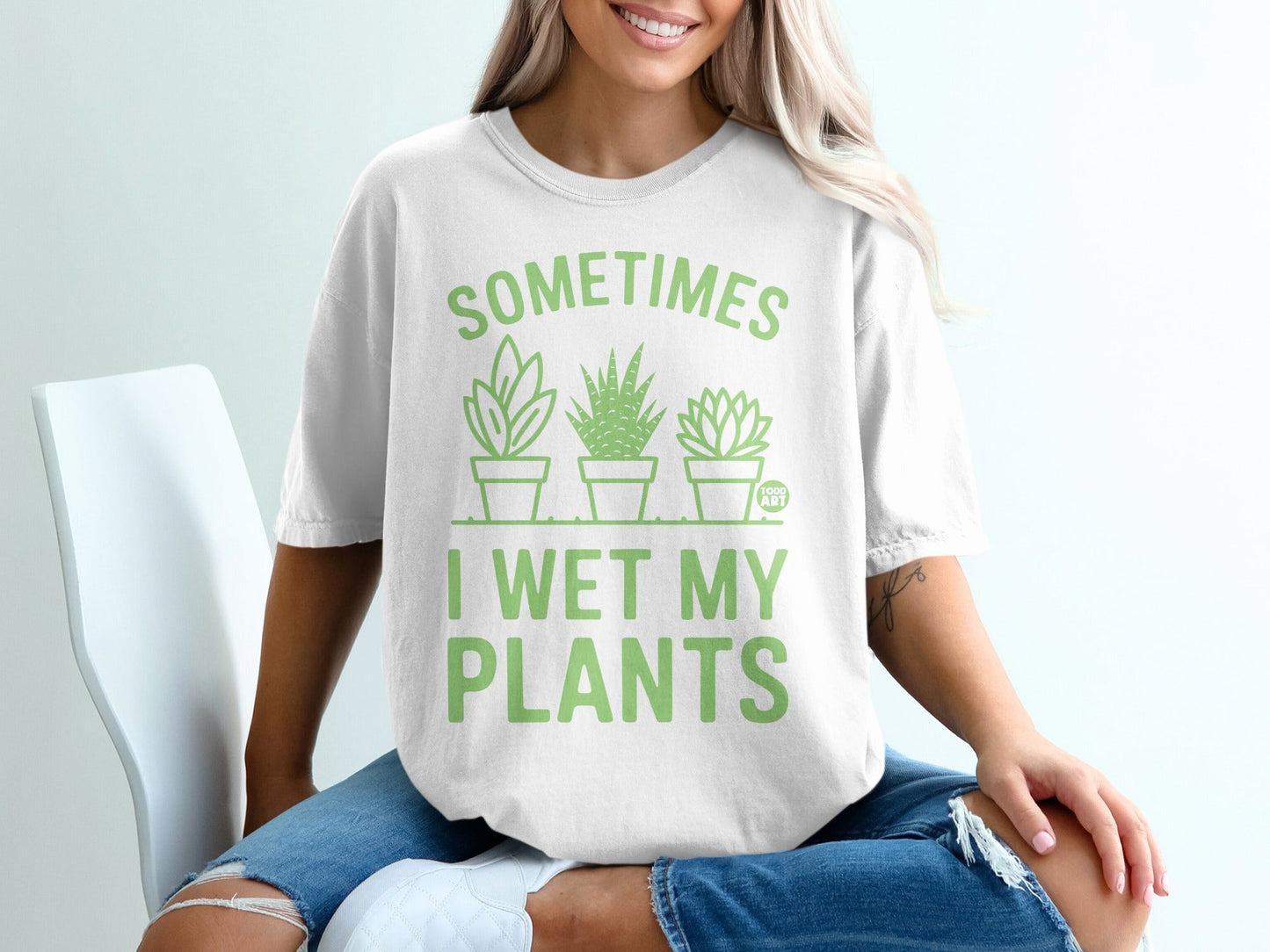 White t-shirt with green graphic text and three potted plants.