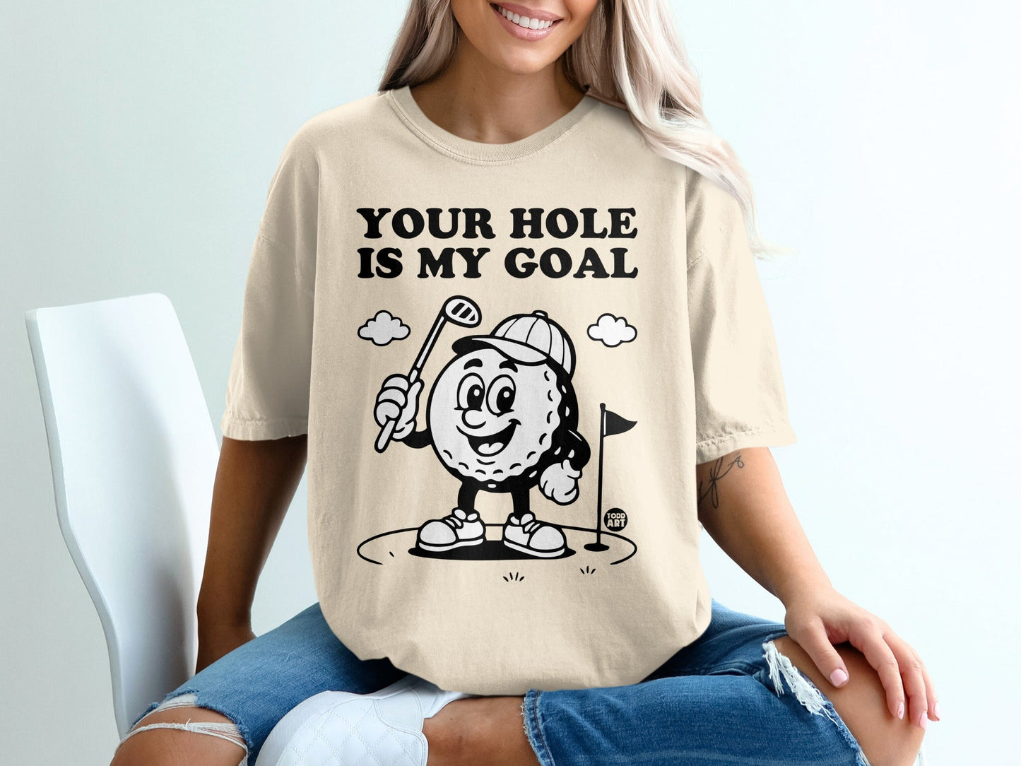 T-shirt with cartoon golf ball, "Your Hole Is My Goal" text, and golf flag.