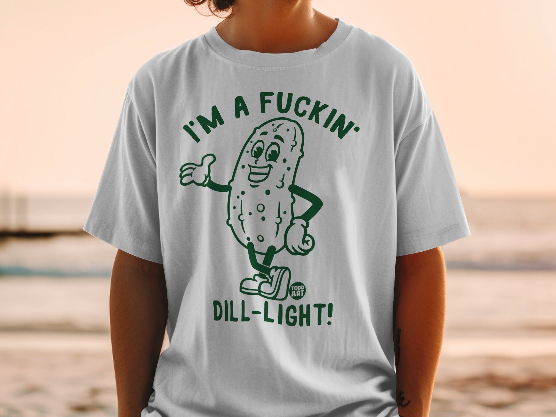T-shirt with a cartoon pickle giving a thumbs-up and the text "I'M A FUCKIN' DILL-LIGHT!".