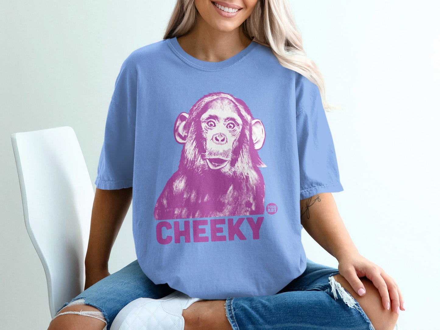 Blue t-shirt with pink chimpanzee graphic and the word "CHEEKY".