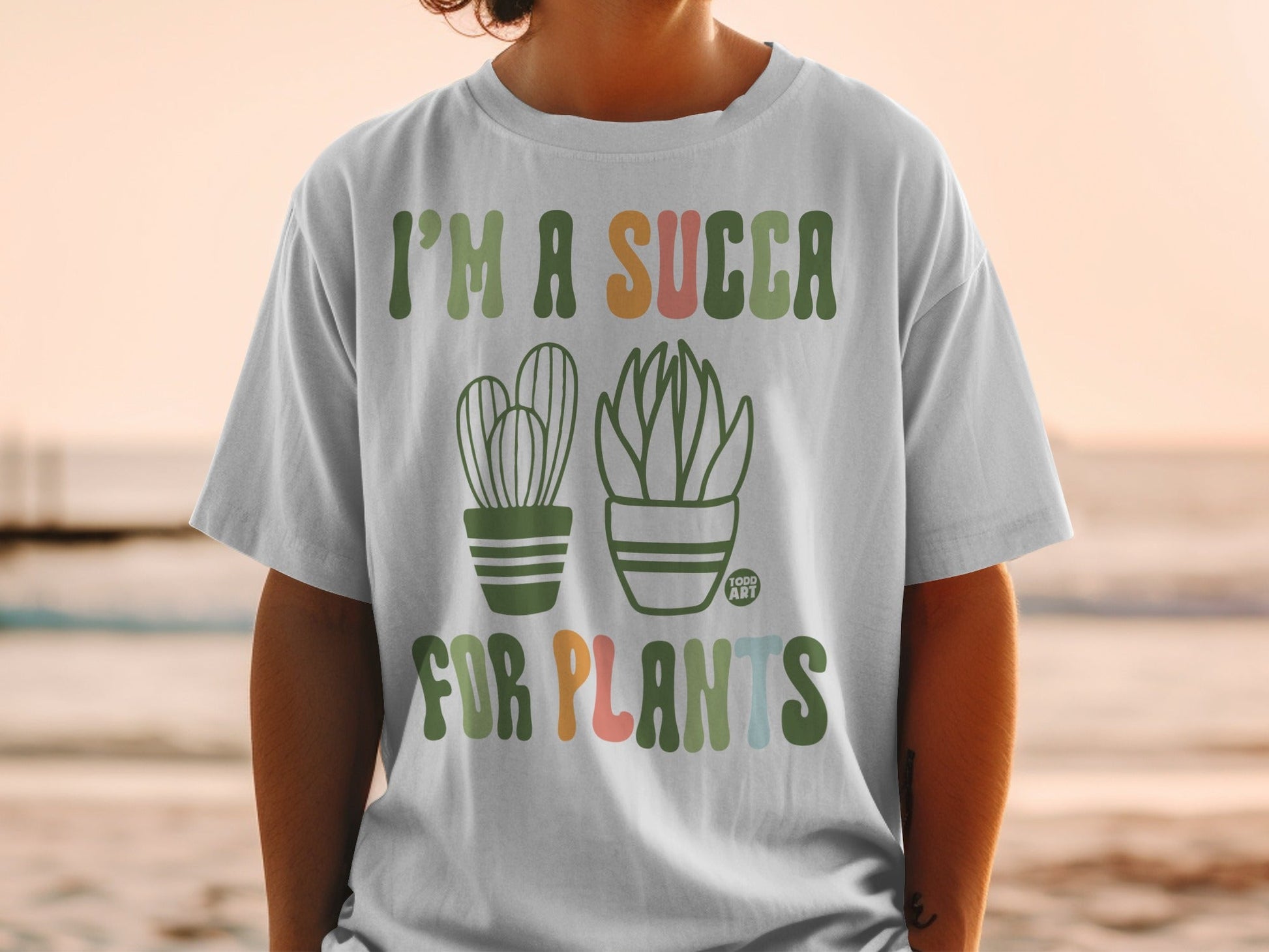 White t-shirt with "I'm a succa for plants" and two cartoon succulents.