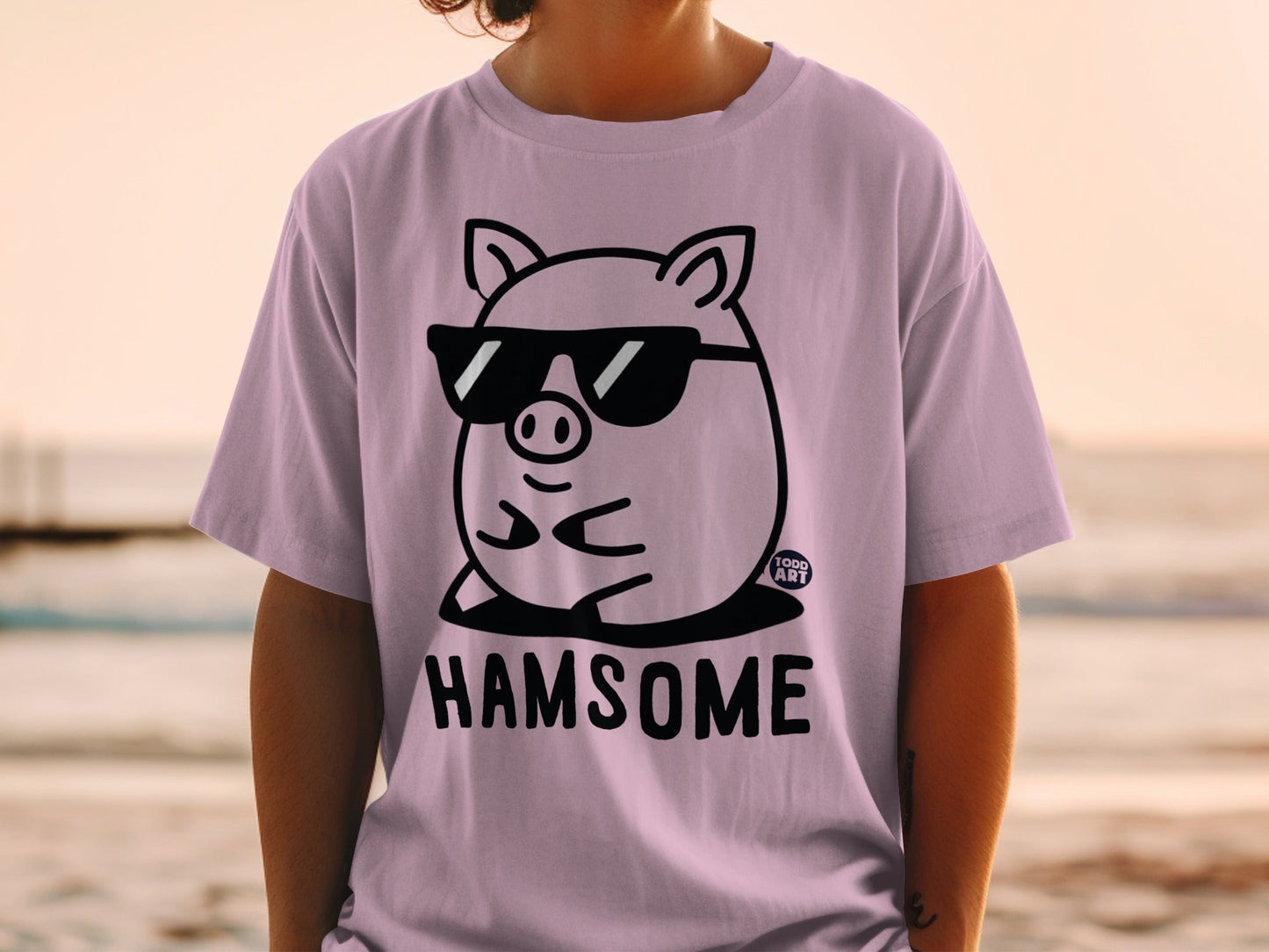 Pink t-shirt with cartoon pig wearing sunglasses and text "HAMSOME".