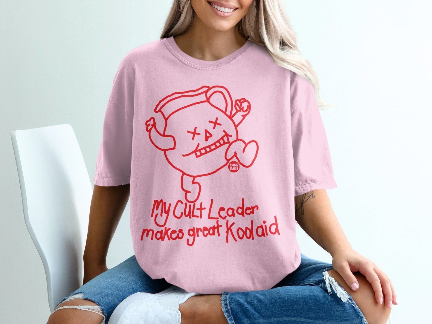 Pink t-shirt with red Kool-Aid man graphic and text.