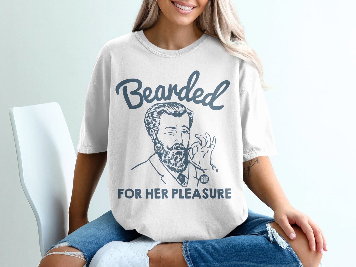 White t-shirt with a drawing of a man and text "Bearded for Her Pleasure."