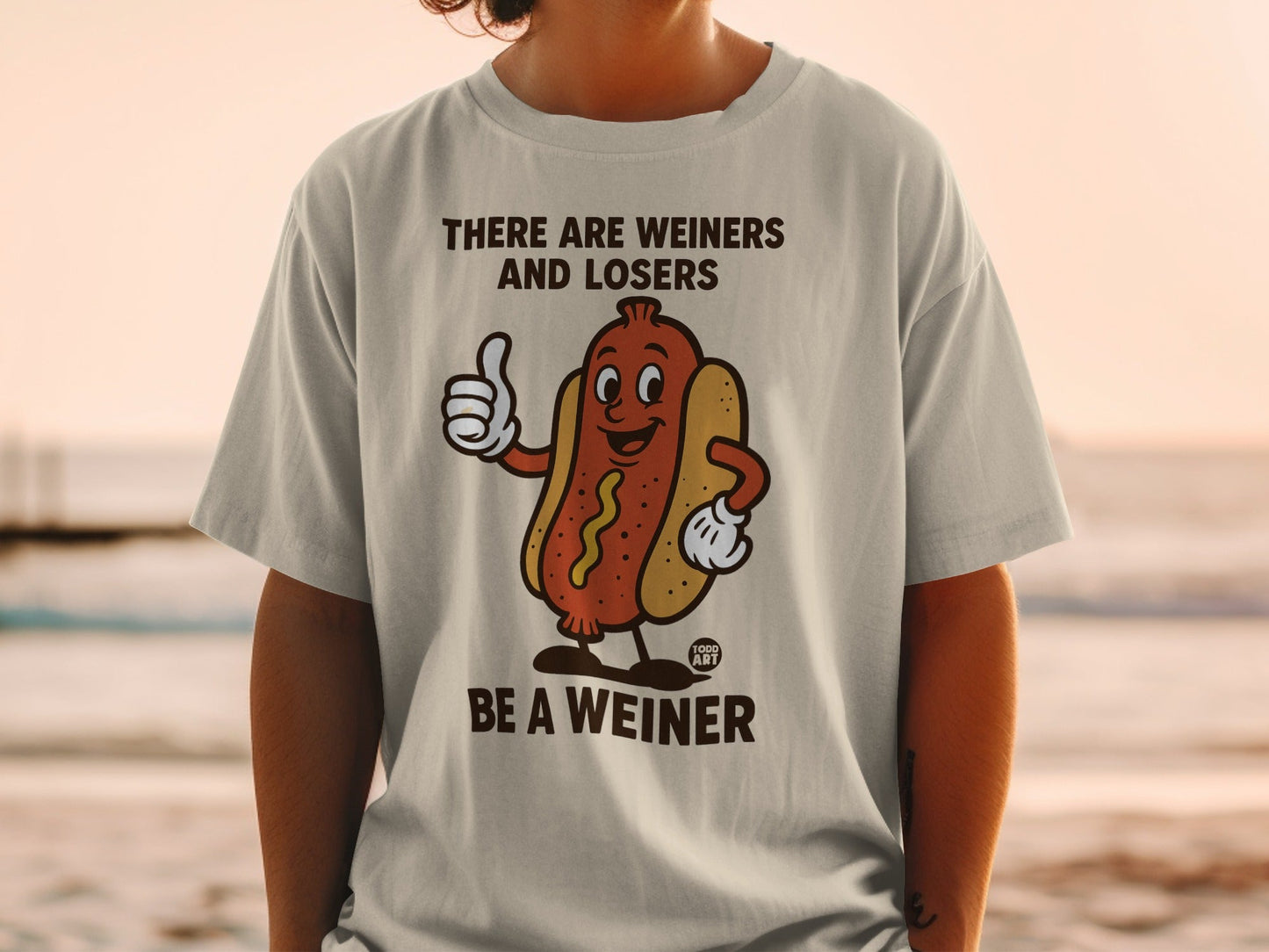 T-shirt with cartoon hot dog giving thumbs up, text "There are weiners and losers Be a weiner".