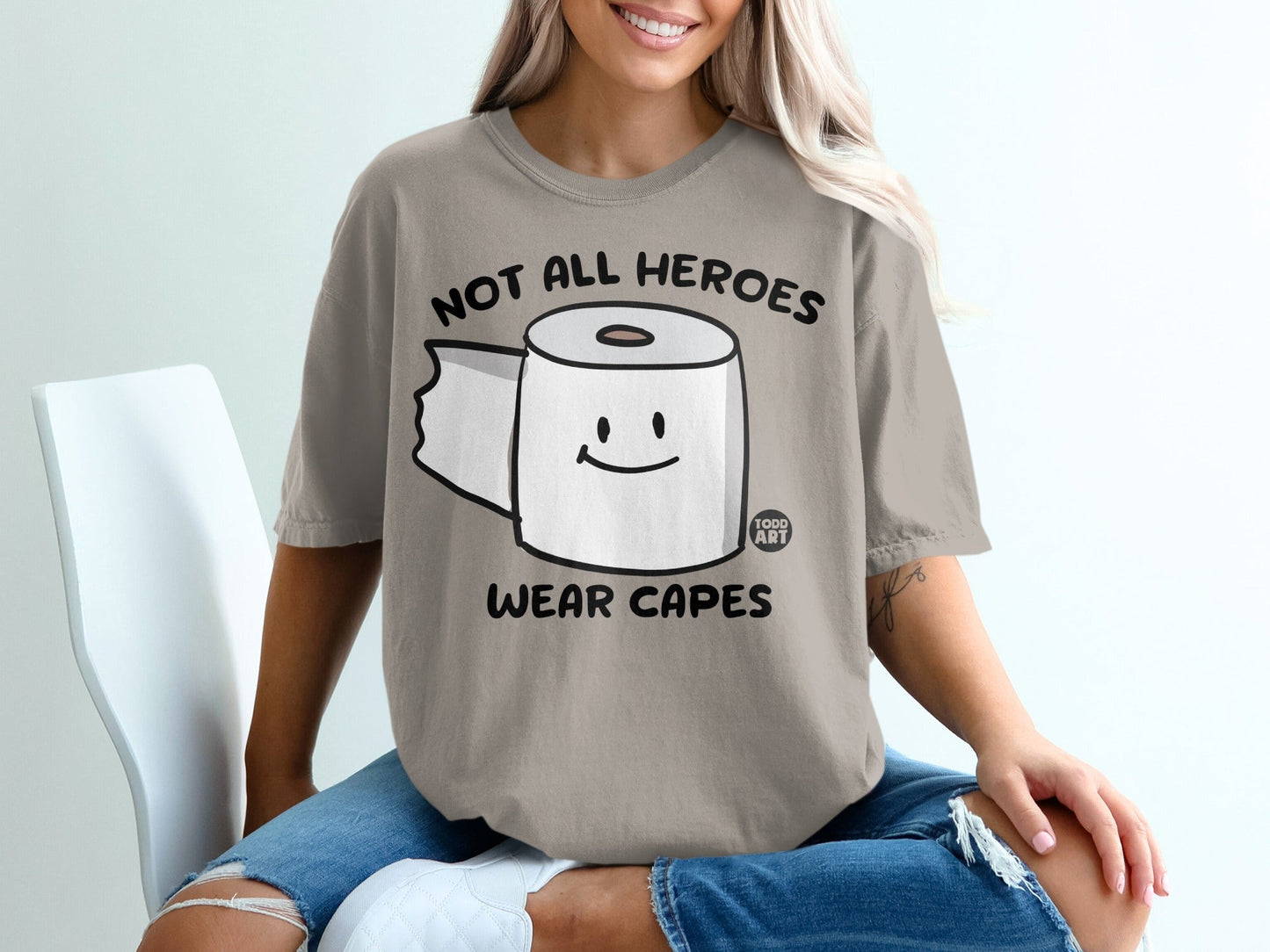 T-shirt with toilet paper roll graphic and "Not all heroes wear capes" text.