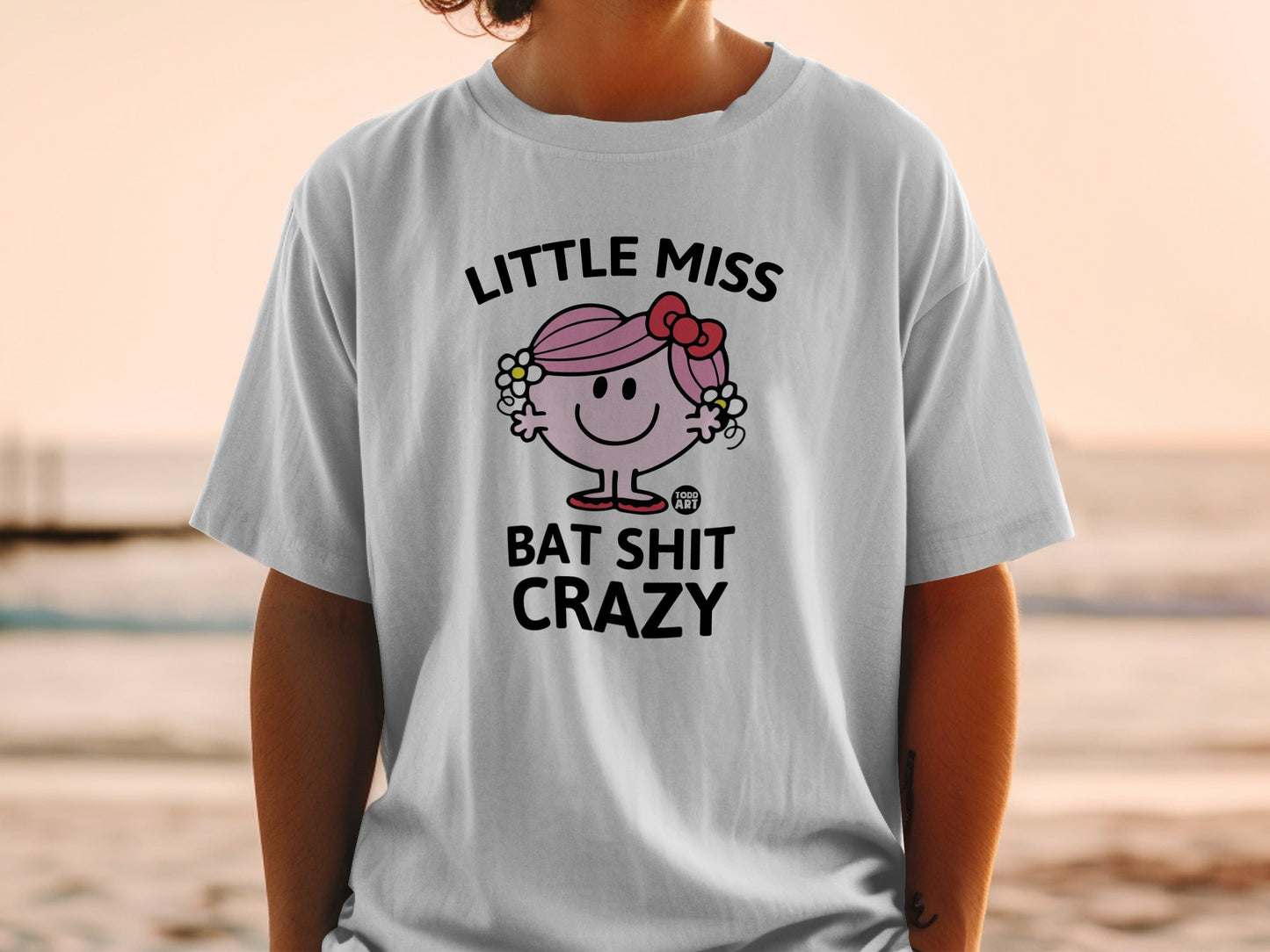 White t-shirt with graphic of Little Miss character and "Bat Shit Crazy" text.