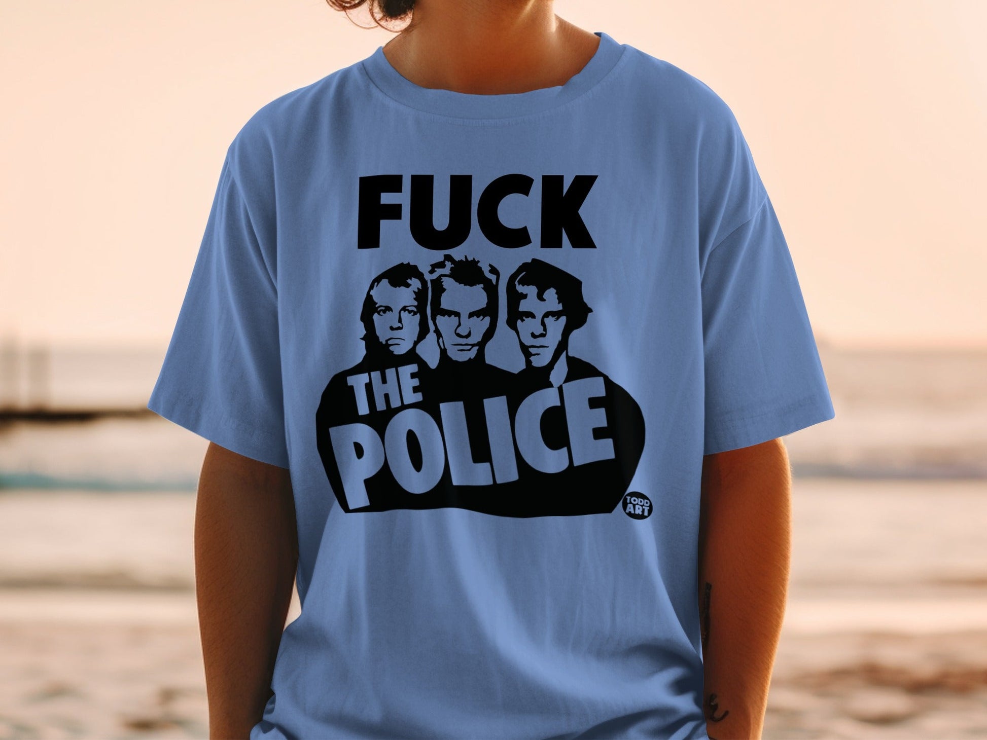 Blue t-shirt with black graphic of The Police band members and text.