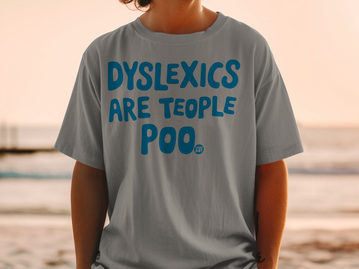Grey t-shirt with blue text "DYSLEXICS ARE TEOPLE POO".