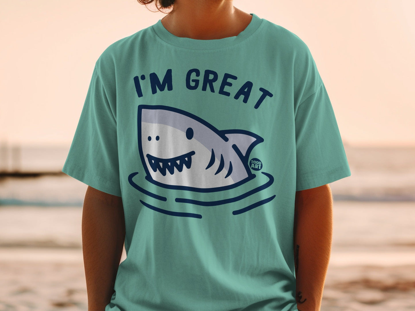 Teal t-shirt with "I'm Great" text and cartoon shark illustration.