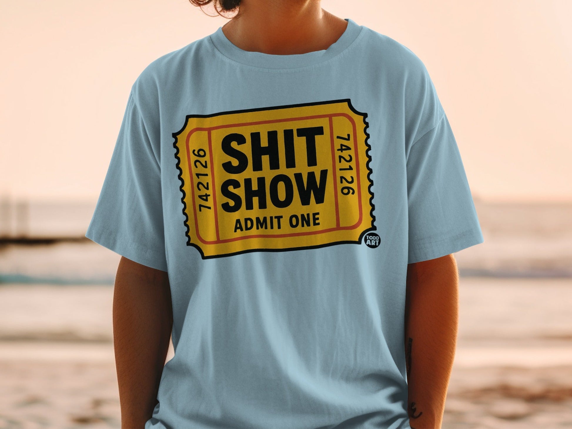 Light blue t-shirt with "SHIT SHOW ADMIT ONE" printed in a ticket design.
