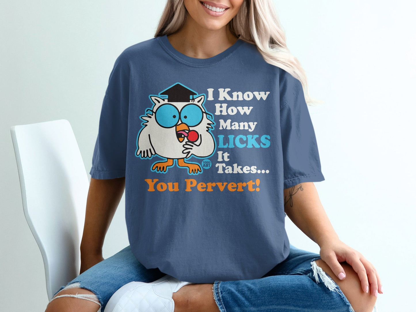 Cartoon owl with lollipop and graduation cap wearing a blue t-shirt.