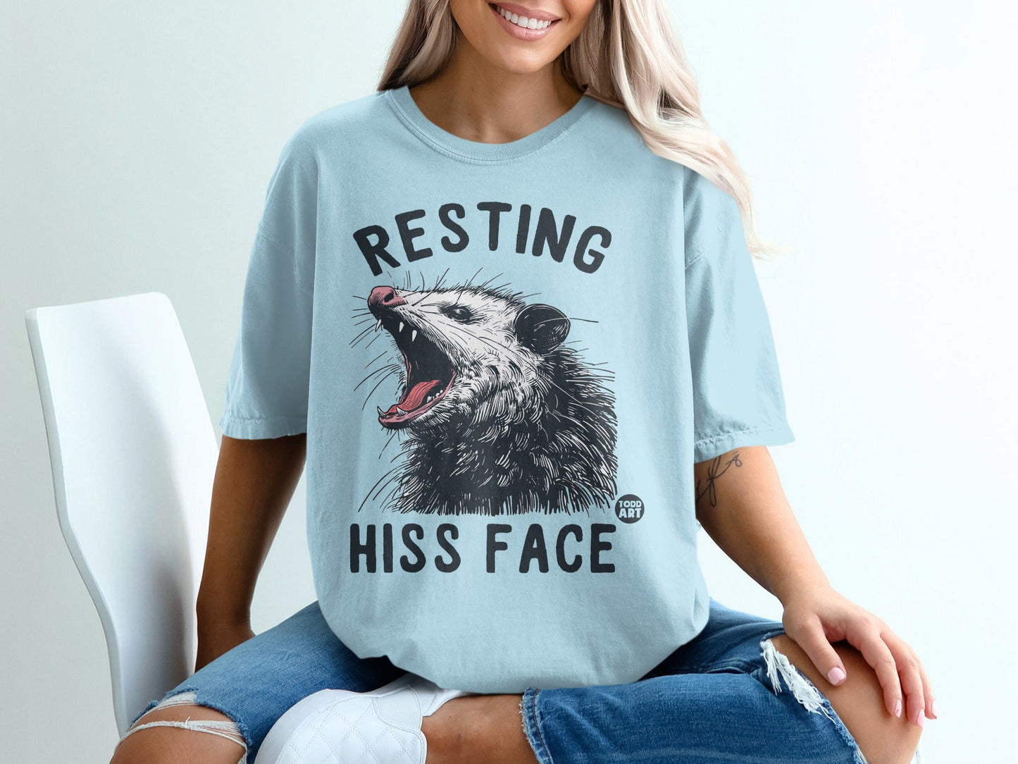 Light blue t-shirt with opossum graphic and "Resting Hiss Face" text.
