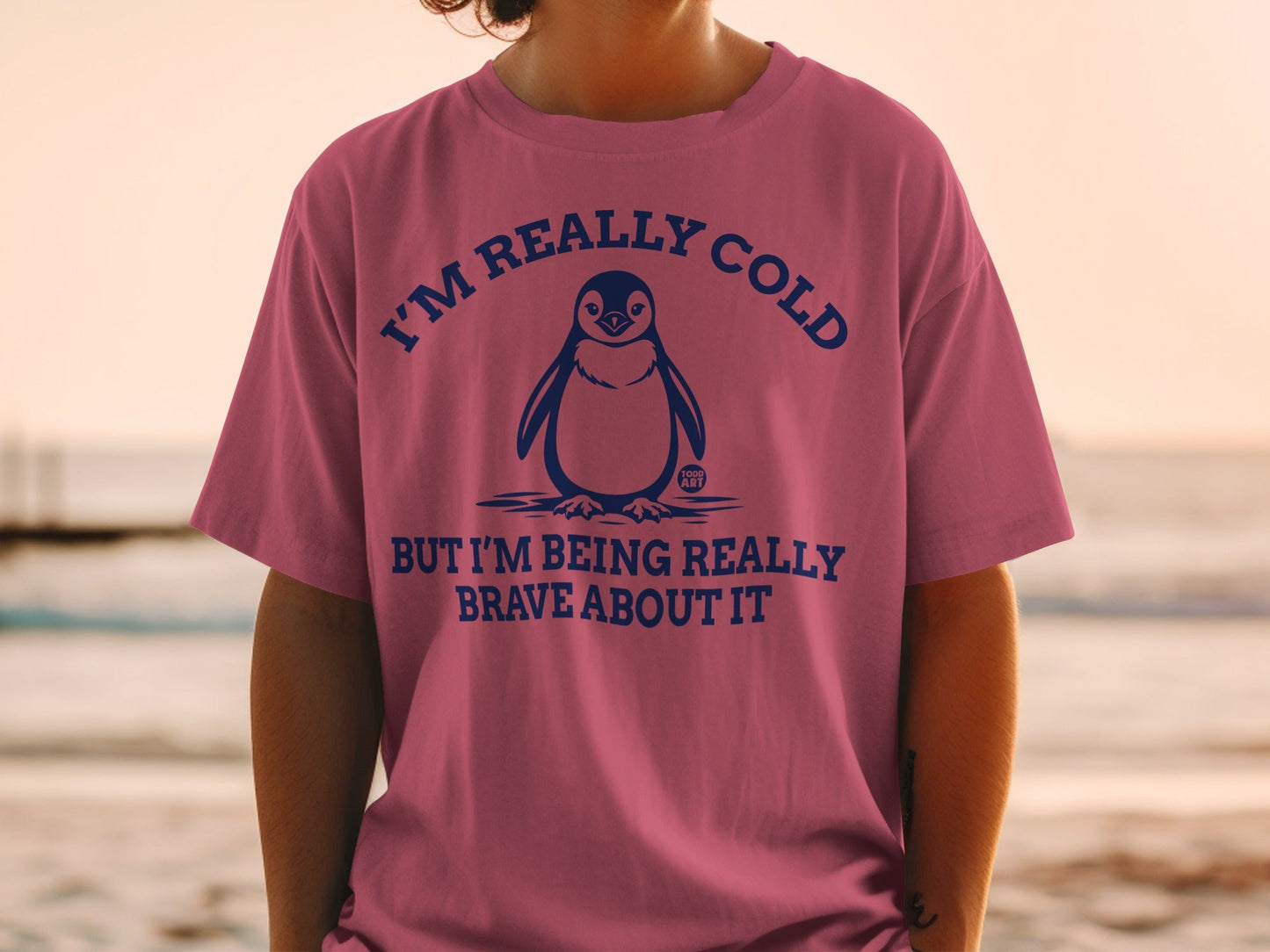 Pink t-shirt with penguin and text "I'm really cold but I'm being really brave about it."