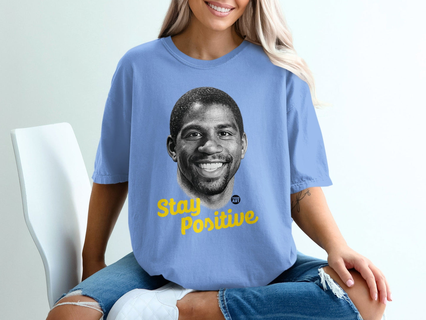 Light blue t-shirt with Magic Johnson's portrait and "Stay Positive" text.