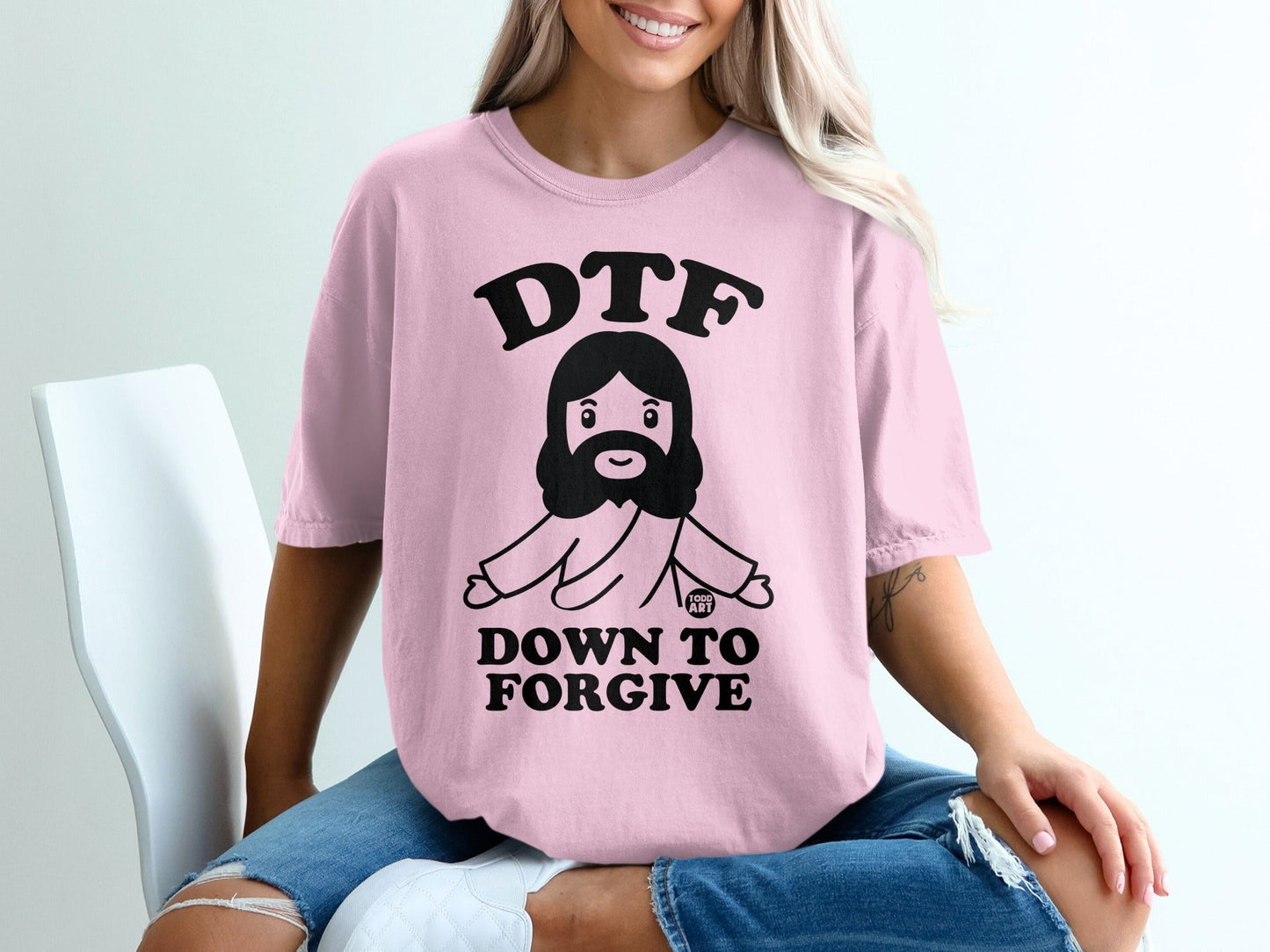 Pink t-shirt with "DTF DOWN TO FORGIVE" and cartoon Jesus graphic.