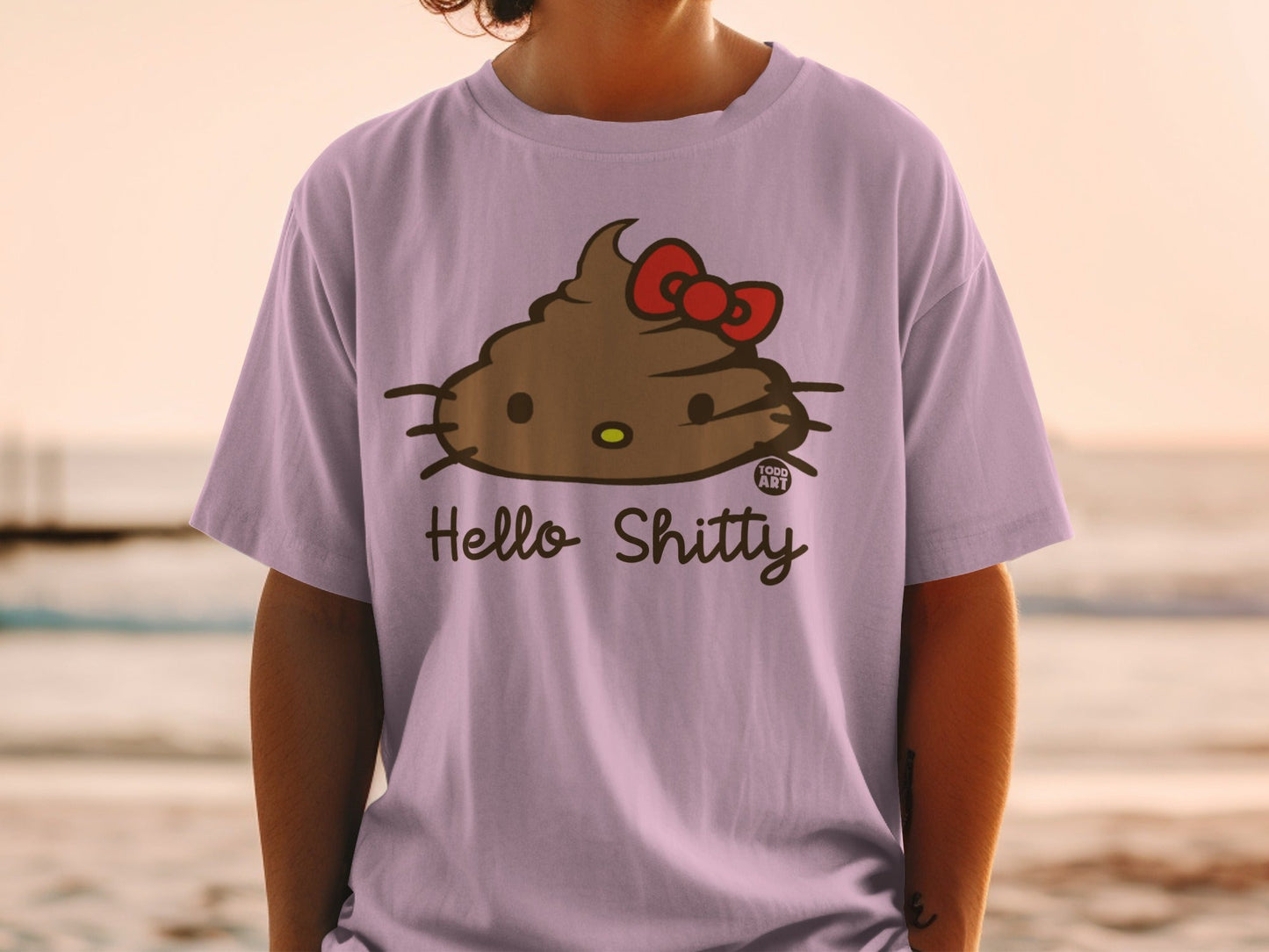 Purple t-shirt with a cartoon brown pile of poop with a red bow, labeled "Hello Shitty".