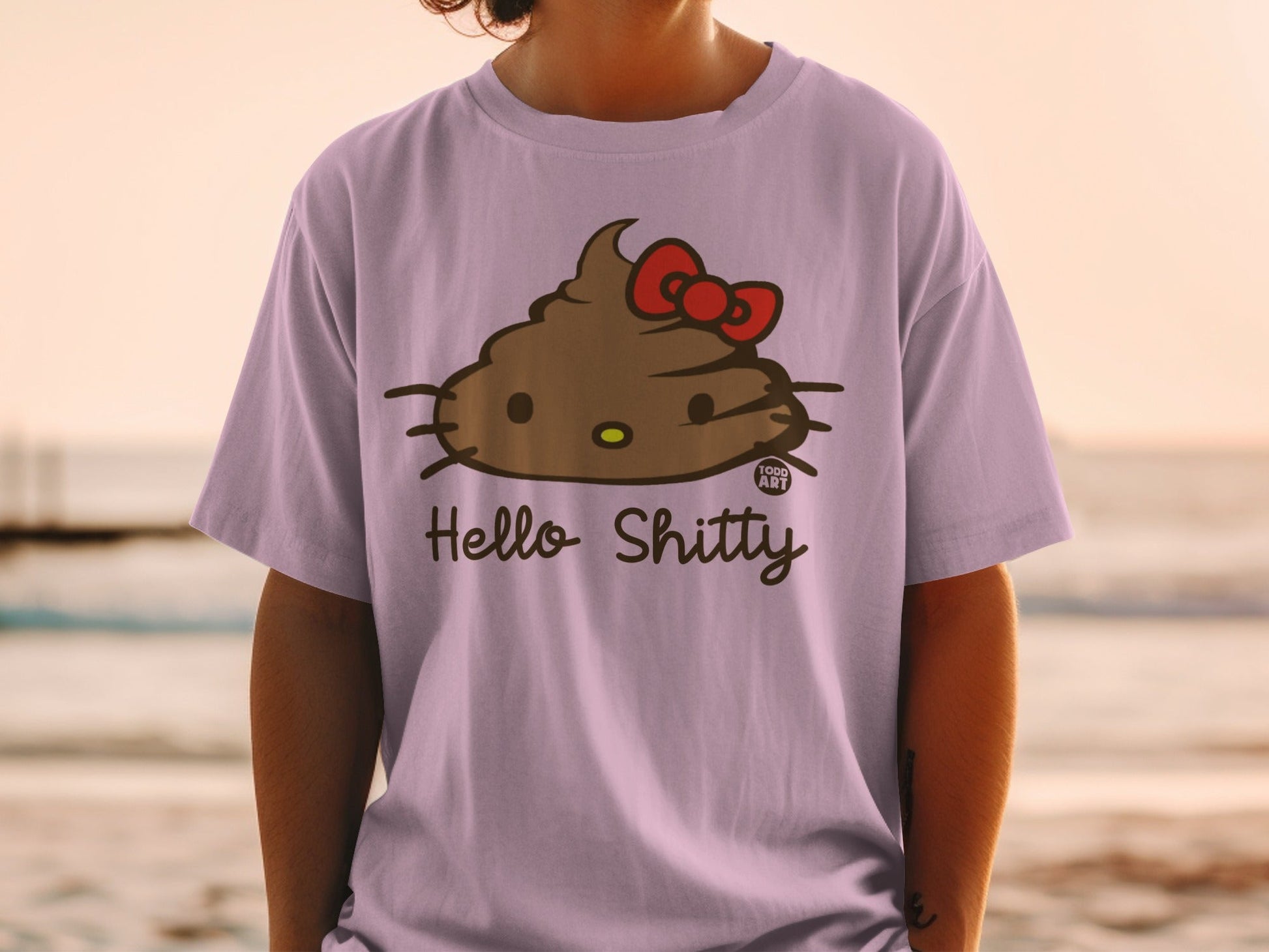 Purple t-shirt with a cartoon brown pile of poop with a red bow, labeled "Hello Shitty".