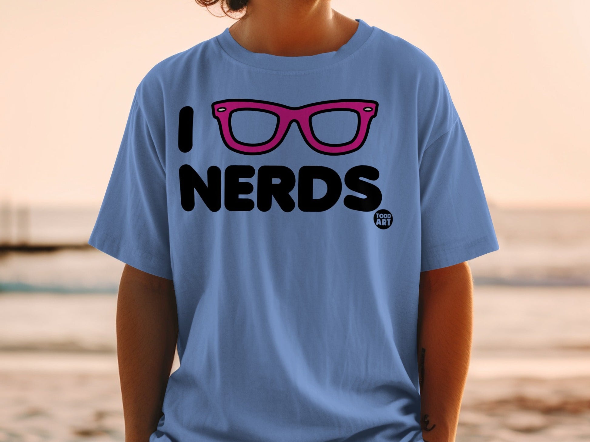 Blue t-shirt with pink glasses and "I LOVE NERDS 1000 ART" text.