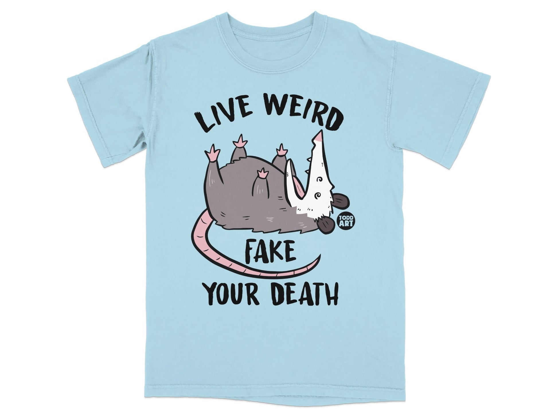 Light blue t-shirt with a possum graphic and "LIVE WEIRD FAKE YOUR DEATH" text.