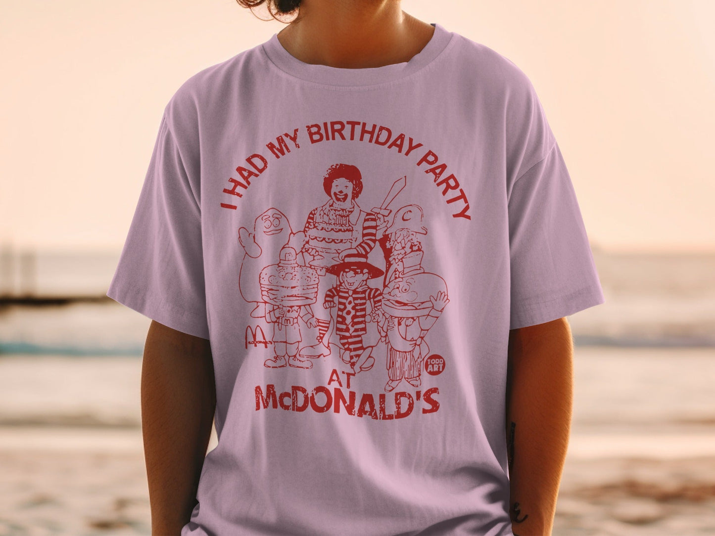 Light purple t-shirt with red graphic of McDonald's characters and text "I HAD MY BIRTHDAY PARTY AT MCDONALD'S".