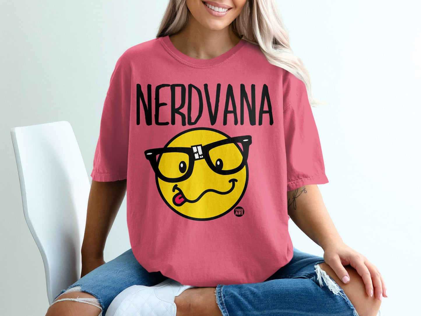 Pink t-shirt with "NERDVANA" text and a smiley face wearing glasses.