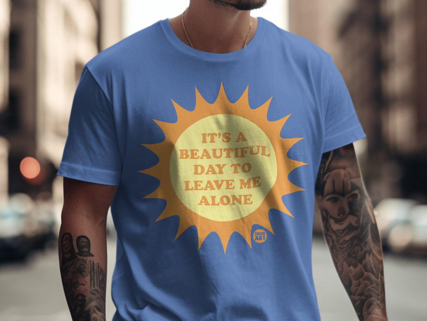 Blue t-shirt with a yellow sun graphic and text "IT'S A BEAUTIFUL DAY TO LEAVE ME ALONE".