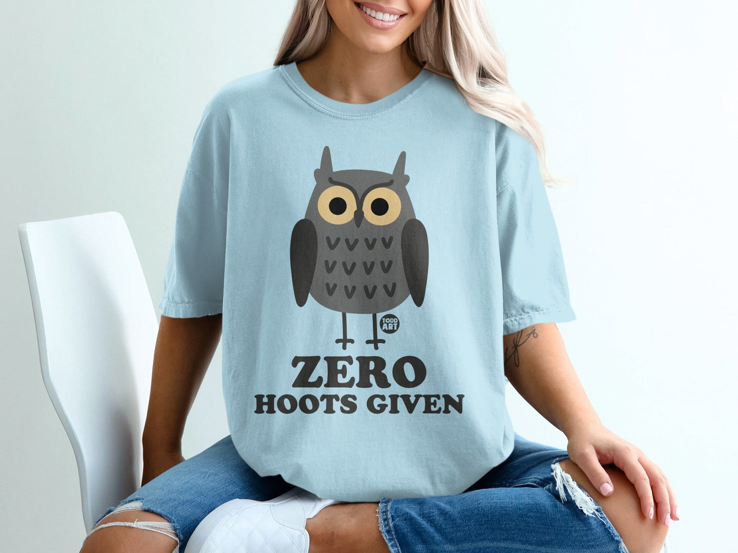 Light blue t-shirt with cartoon owl graphic and text "ZERO HOOTS GIVEN".