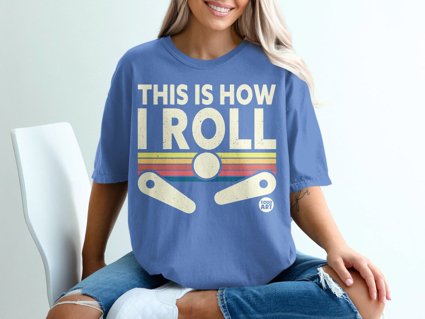 Blue t-shirt with "THIS IS HOW I ROLL" text and a retro pinball graphic.