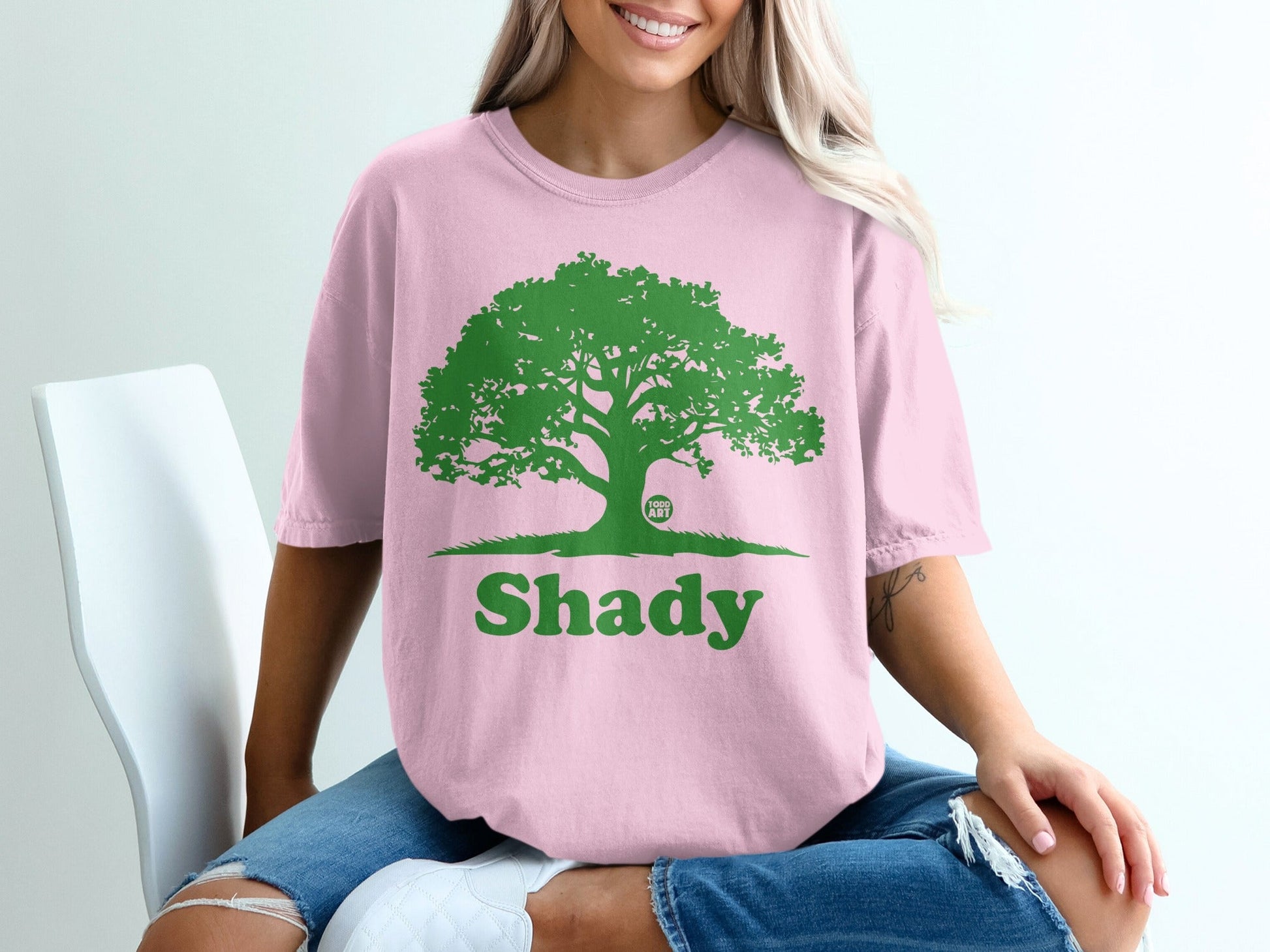 Pink t-shirt with a green tree graphic and "Shady" text.