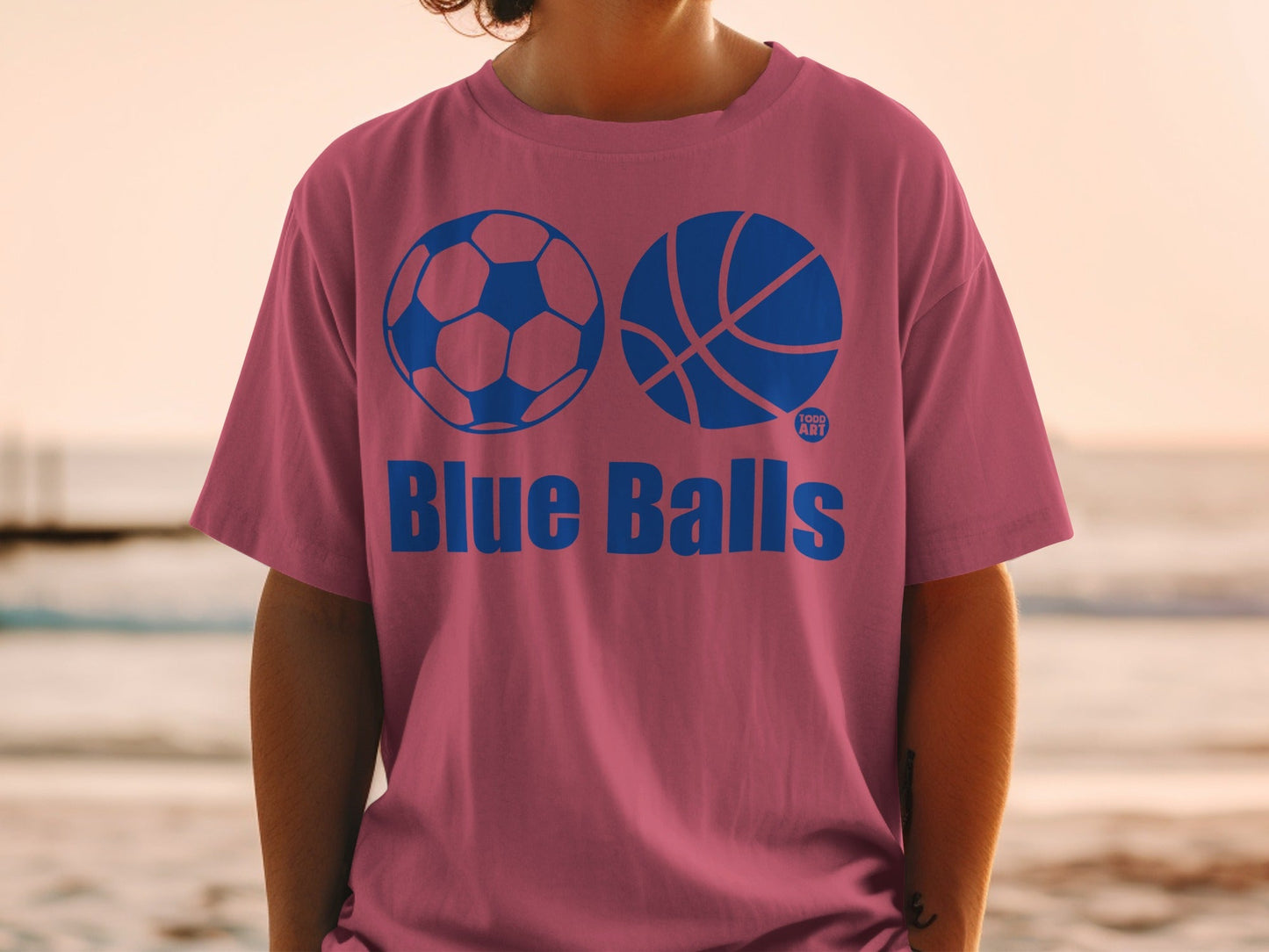 Pink t-shirt with blue soccer ball and basketball graphics and "Blue Balls" text.