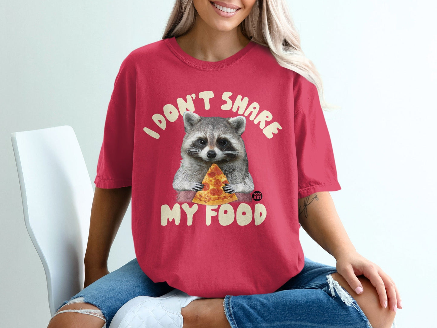 Red t-shirt with raccoon eating pizza and text "I DON'T SHARE MY FOOD".