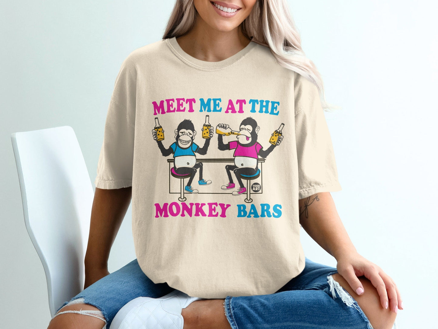 T-shirt with cartoon monkeys at a bar drinking beer, text "MEET ME AT THE MONKEY BARS".