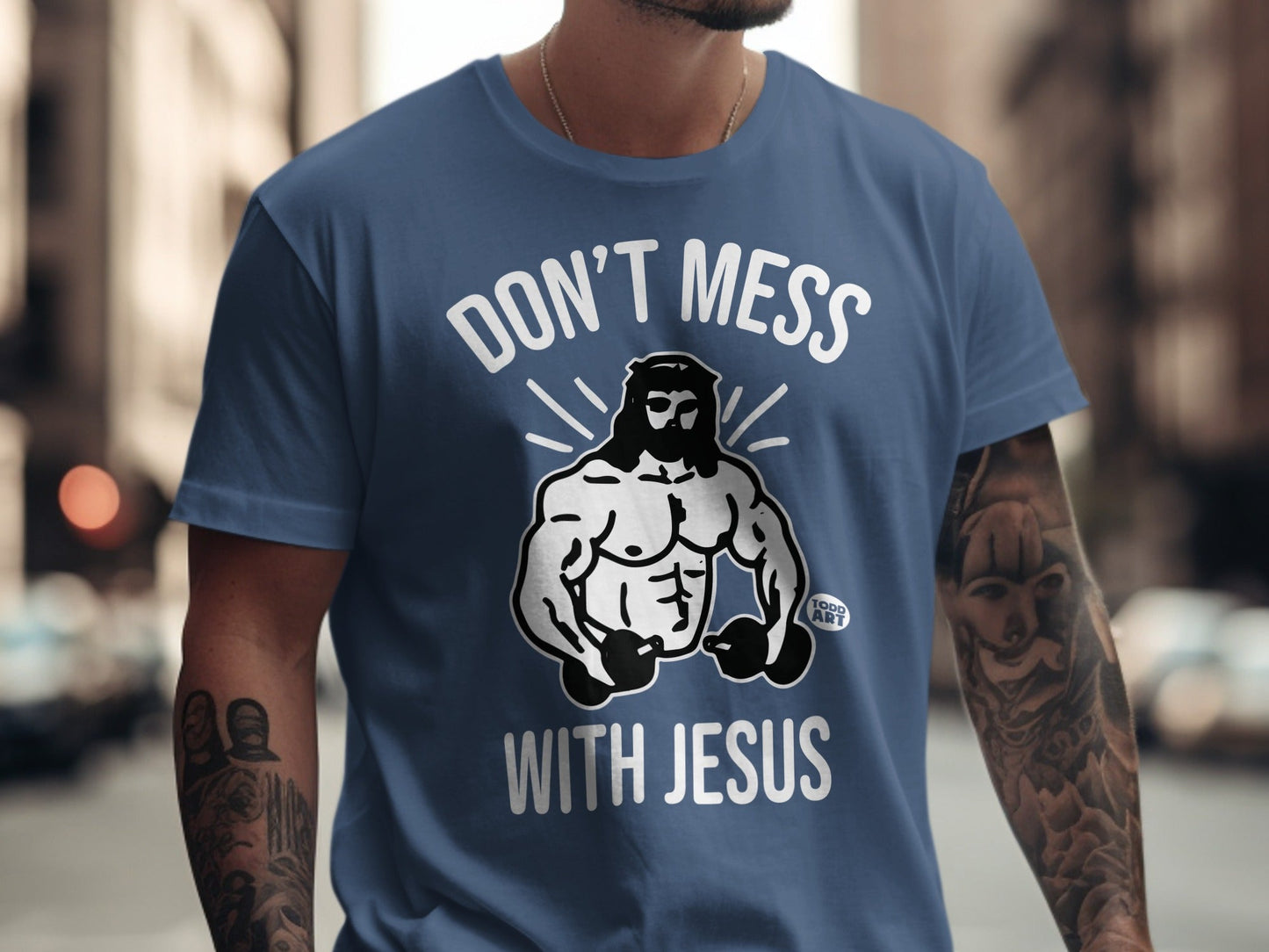 Blue t-shirt with "Don't Mess With Jesus" and muscular Jesus graphic.
