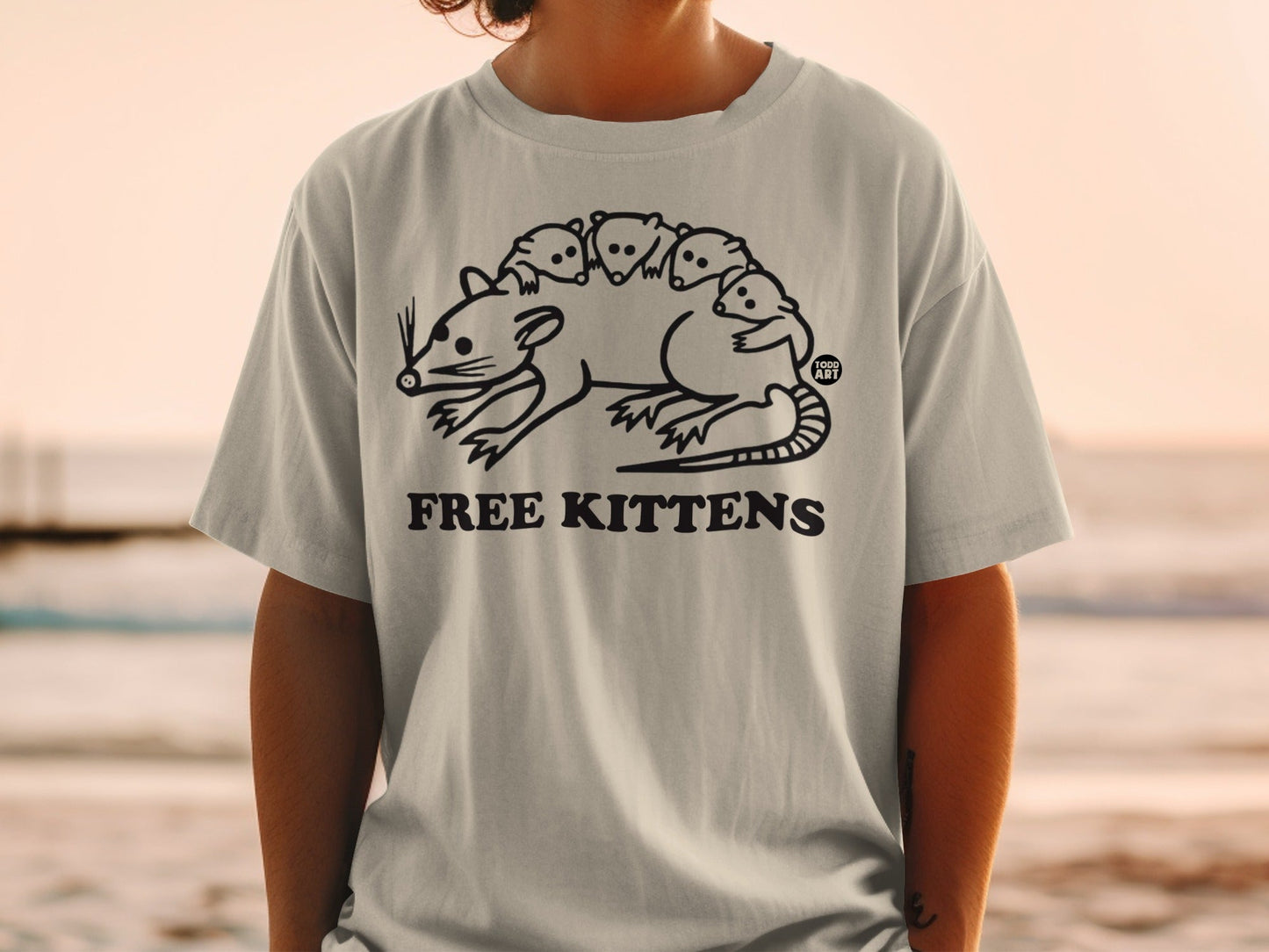 T-shirt with cartoon drawing of a large rat with five small kittens on its back.